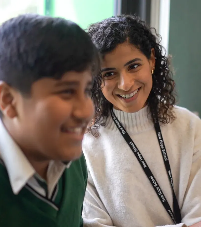 Teacher smiling with student in class at New Hope Christian School